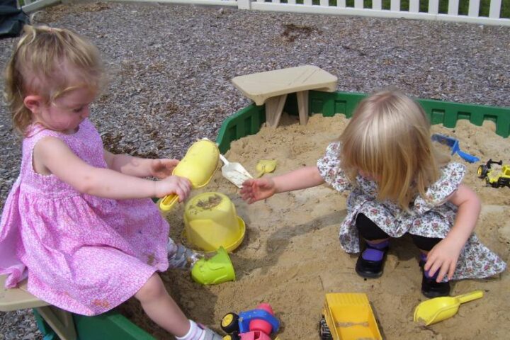 Two small children playing in a sandbox
